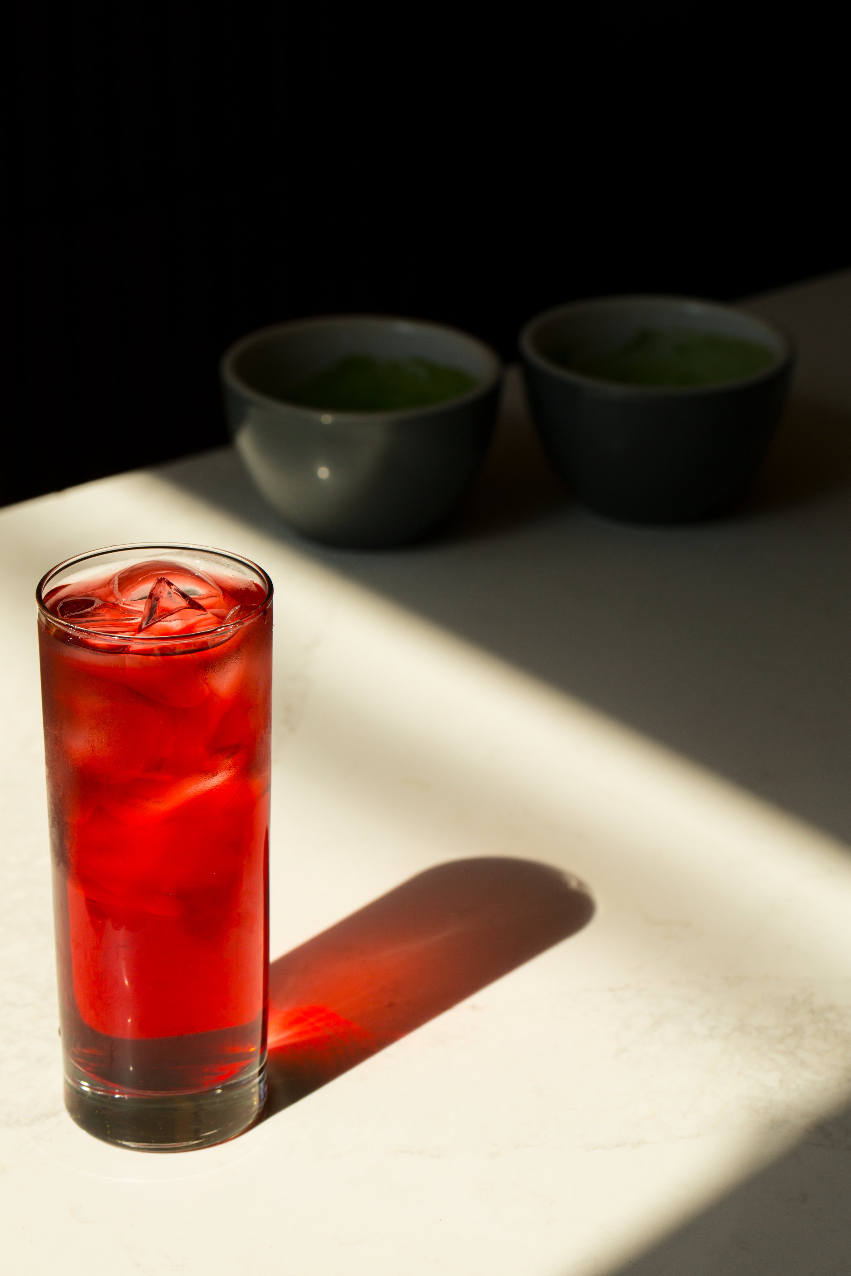glass-with-iced-red-beverage-reflects-on-a-white-table.jpg